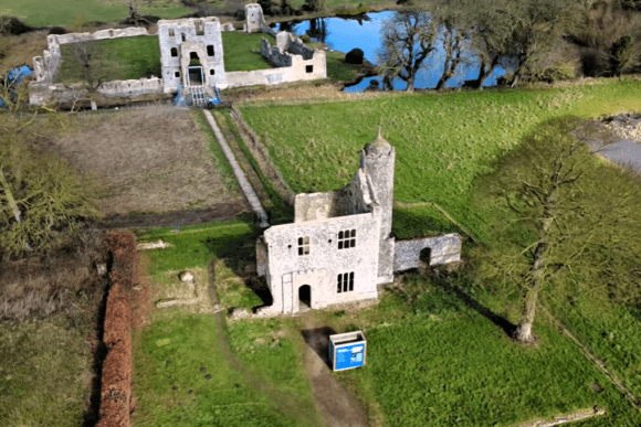 Aerial view of Baconsthorpe Castle gatehouse and outer ruins with moat and countryside in Norfolk