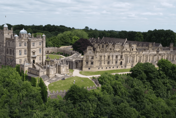 Aerial view of Bolsover Castle in Derbyshire showing the Little Castle, terrace gardens, stone fortifications, and surrounding woodland