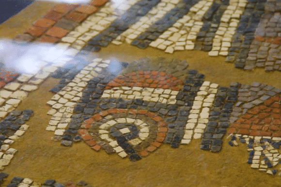 Close-up of a Roman mosaic floor fragment with coloured stone tiles at the Aldborough Roman Site.