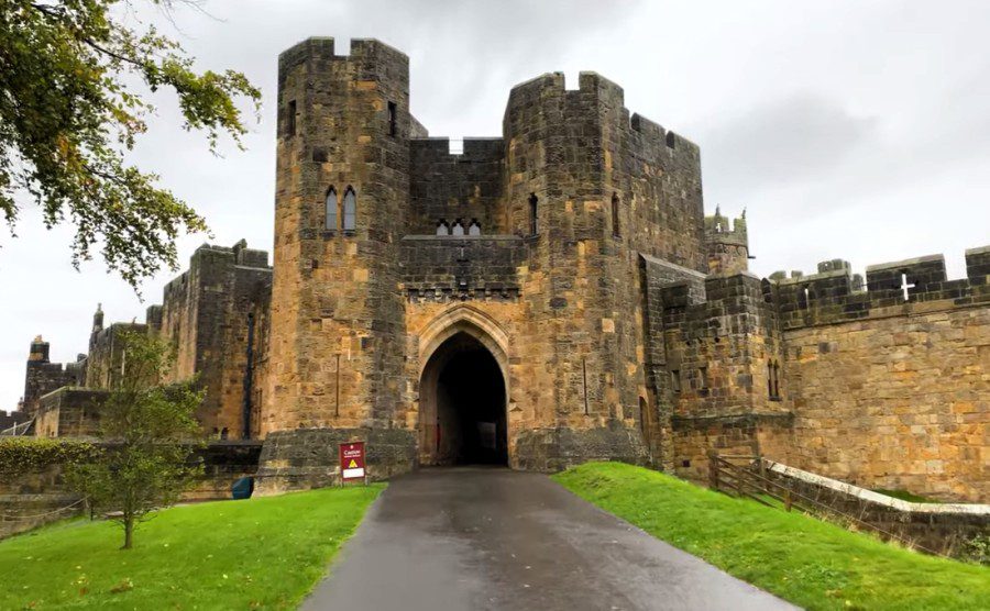Entrance gate and medieval stone towers of Alnwick Castle in Northumberland, England.