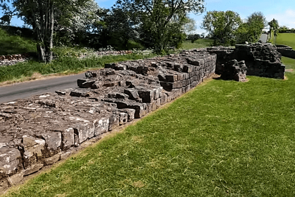 Stone ruins of Banks East Turret on Hadrian’s Wall beside a rural road in Northumberland, England