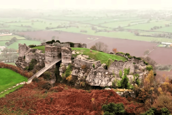 Aerial view of Beeston Castle ruins on a misty hilltop overlooking the Cheshire Plain