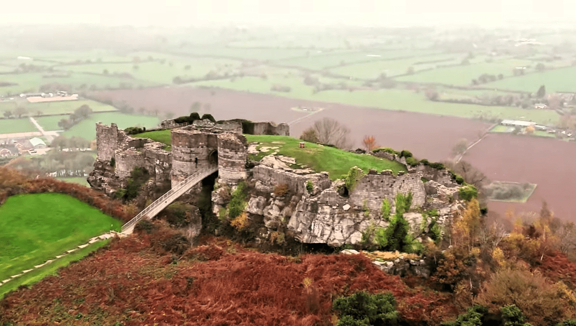 Aerial view of Beeston Castle ruins on a misty hilltop overlooking the Cheshire Plain