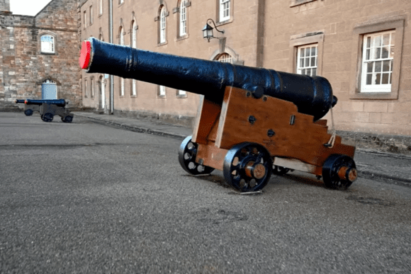 Historic cannon on a wooden carriage displayed in the courtyard of Berwick Barracks in Northumberland.