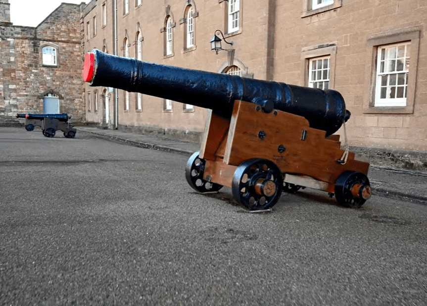 Historic cannon on a wooden carriage displayed in the courtyard of Berwick Barracks in Northumberland.