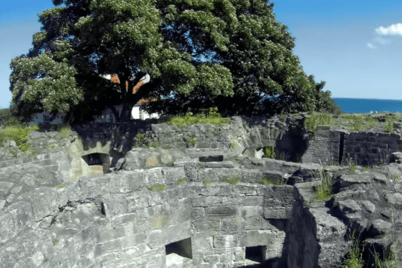Stone ruins of Berwick-upon-Tweed’s Elizabethan ramparts with coastal views and trees in the background.