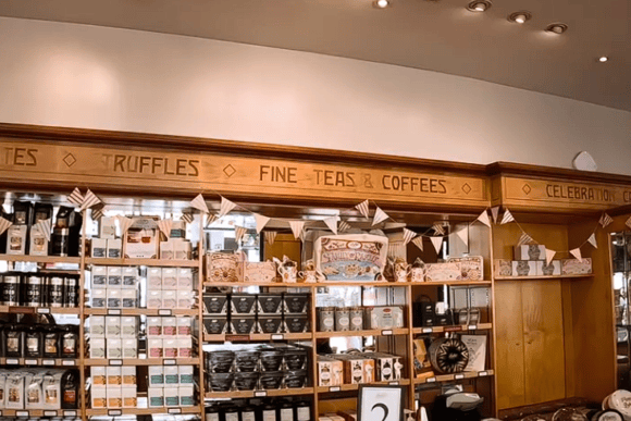 Interior gift shop at Bettys Café Tea Rooms featuring shelves of fine teas, coffees, chocolates, truffles and traditional Yorkshire food gifts.