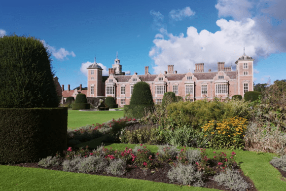 Jacobean red-brick mansion viewed across manicured gardens at Blickling Estate, Norfolk