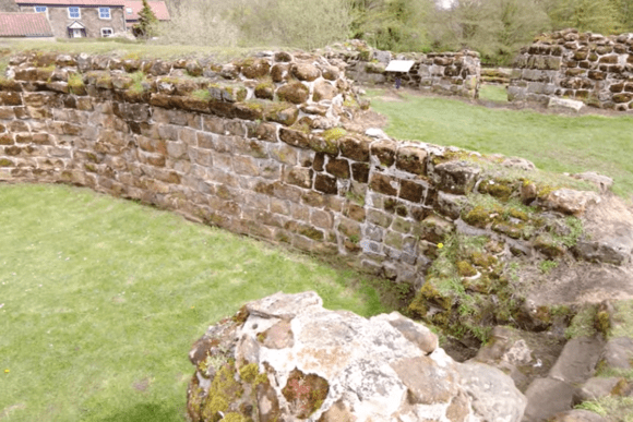Stone ruins of Bolingbroke Castle in Lincolnshire with moss-covered walls and grassy interior