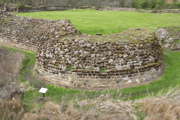 Curved moss-covered stone walls and grassy interior of Bolingbroke Castle ruins, Lincolnshire