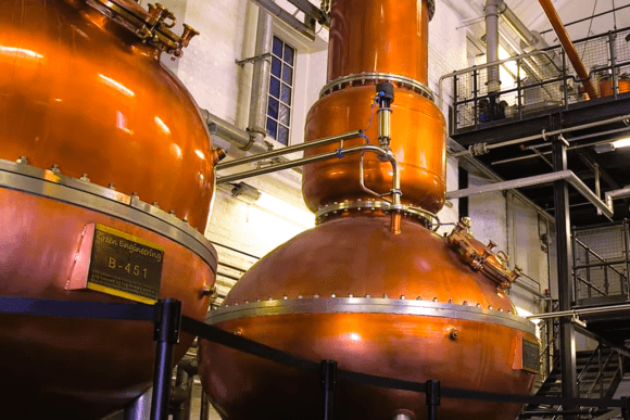 Traditional copper pot stills inside the Bombay Sapphire Distillery in Hampshire, where premium gin is distilled using a unique vapour infusion process.
