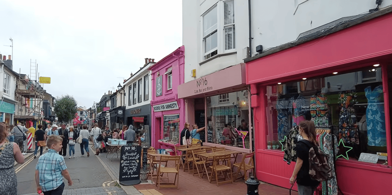 Colourful independent shops, cafés and pedestrians along a busy street in Brighton’s North Laine, one of the city’s popular shopping districts.