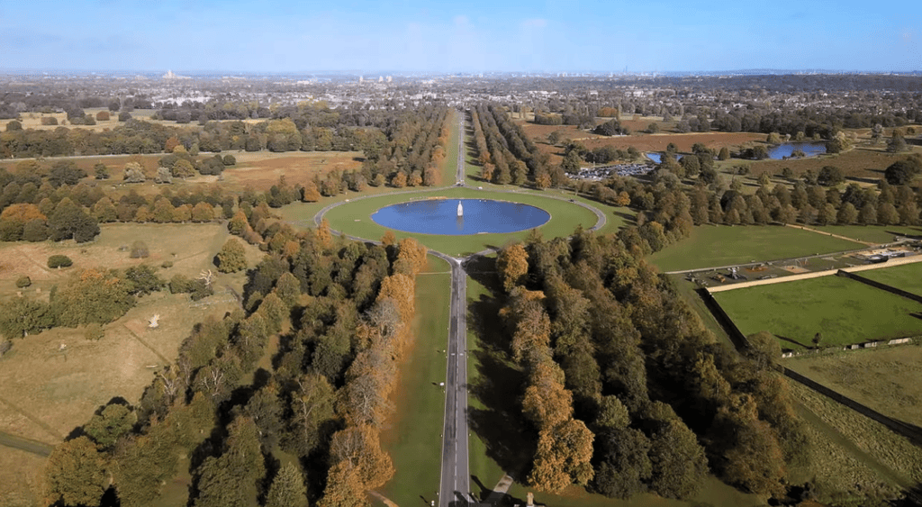 Aerial view of Bushy Park in London featuring the iconic Diana Fountain, Chestnut Avenue, expansive parkland, woodland, and surrounding Royal Park landscapes.