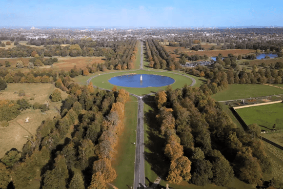 Aerial view of Bushy Park in London featuring the iconic Diana Fountain, Chestnut Avenue, expansive parkland, woodland, and surrounding Royal Park landscapes.