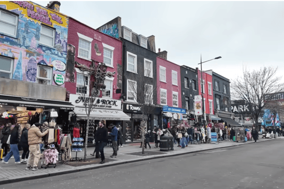 Busy street at Camden Market in London with colourful shopfronts, street art, independent stores and visitors exploring the famous Camden shopping district.