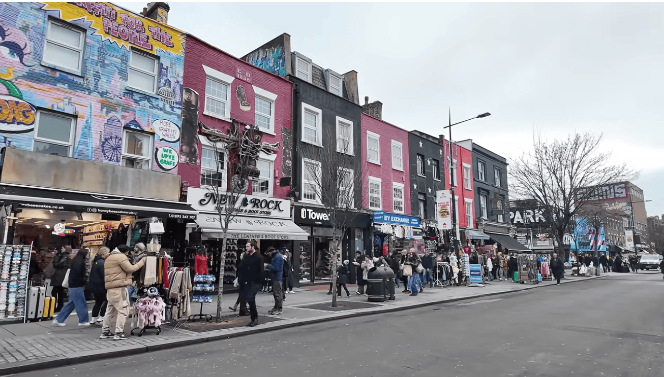 Busy street at Camden Market in London with colourful shopfronts, street art, independent stores and visitors exploring the famous Camden shopping district.