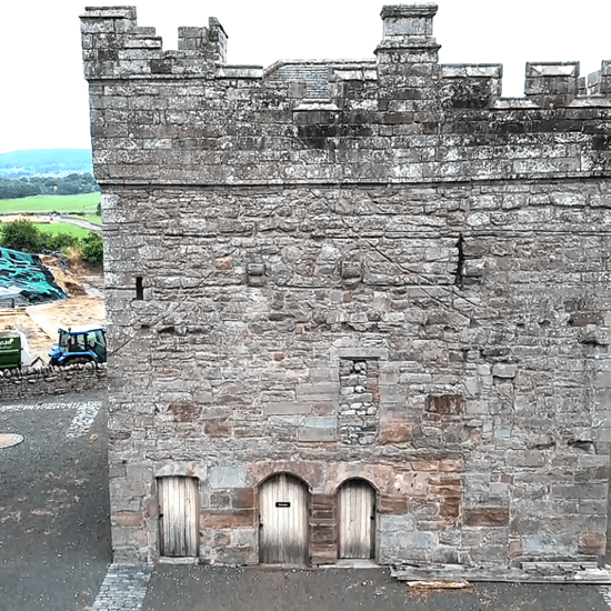 Stone tower with crenellated parapet at Clifton Hall, viewed from the courtyard.