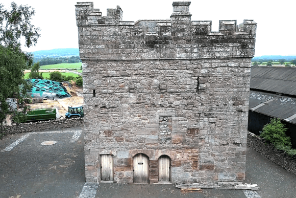 Stone tower with crenellated parapet at Clifton Hall, viewed from the courtyard.