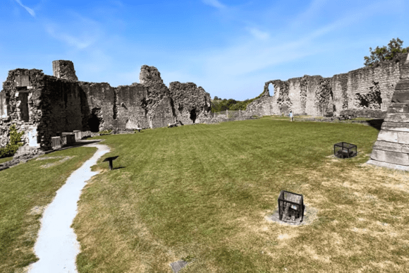 Inner bailey of Conisbrough Castle with grass courtyard and surrounding stone curtain walls.