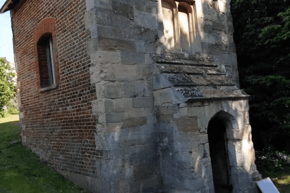 Exterior view of Coombe Conduit showing brick and stone walls with a small arched doorway.