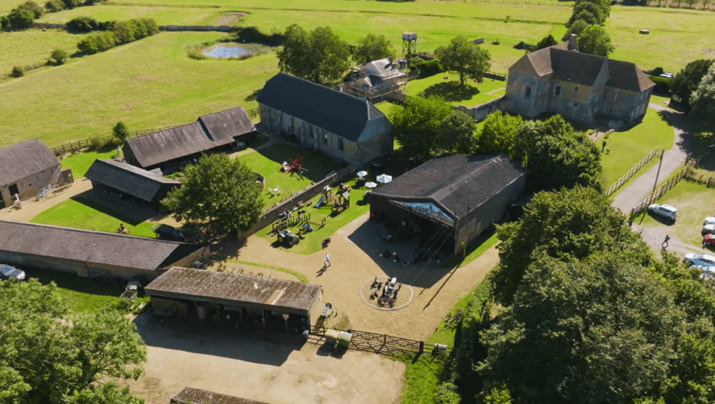 Aerial view of Denny Abbey & Farmland Museum showing historic farm buildings, open courtyards, and surrounding countryside.
