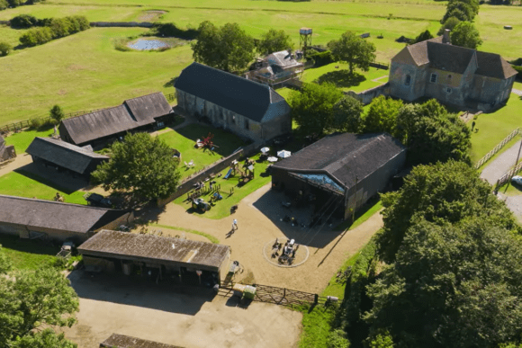 Aerial view of Denny Abbey & Farmland Museum showing historic farm buildings, open courtyards, and surrounding countryside.