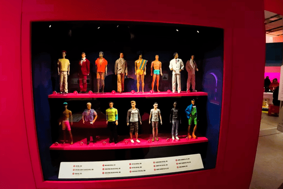 Fashion and design exhibition at the Design Museum in London featuring collectible dolls dressed in diverse clothing styles, showcasing the evolution of fashion, identity, and contemporary design.