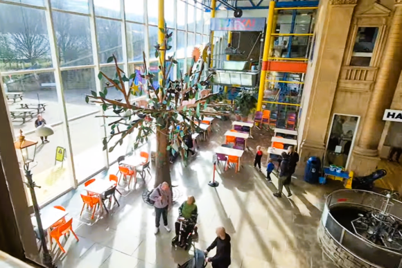 Bright atrium inside Eureka! The National Children’s Museum featuring a large interactive tree sculpture, family seating areas, and hands-on learning spaces illuminated by natural light.