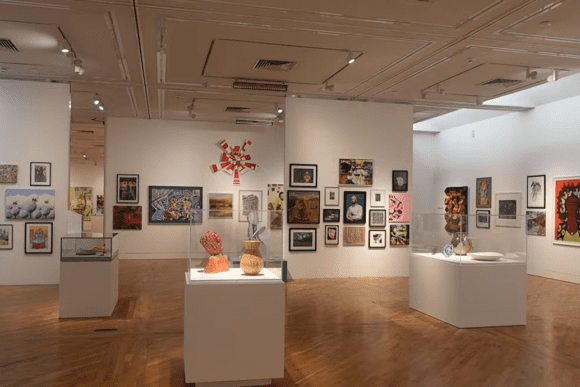 Interior gallery space at Ferens Art Gallery in Hull, displaying a diverse collection of contemporary paintings, sculptures, ceramics, and mixed-media artworks in a bright exhibition hall.