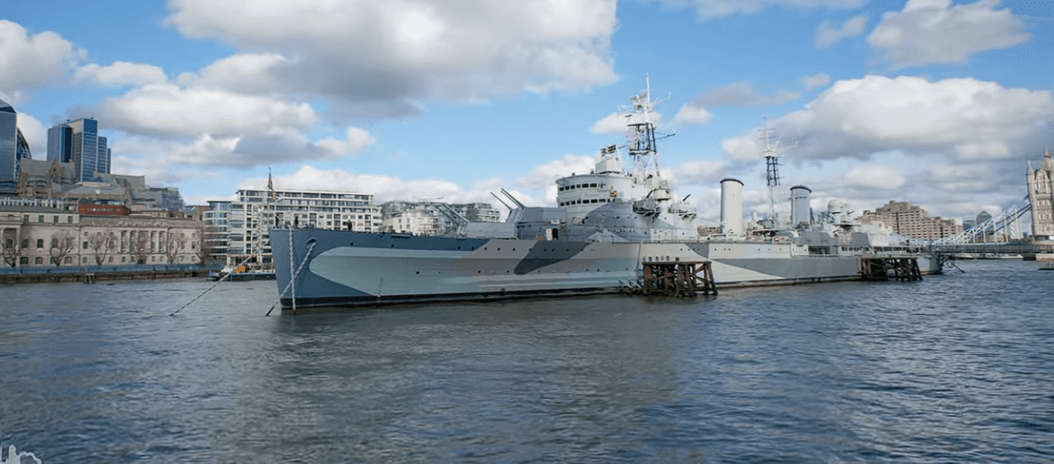 HMS Belfast warship moored on the River Thames near Tower Bridge in London.