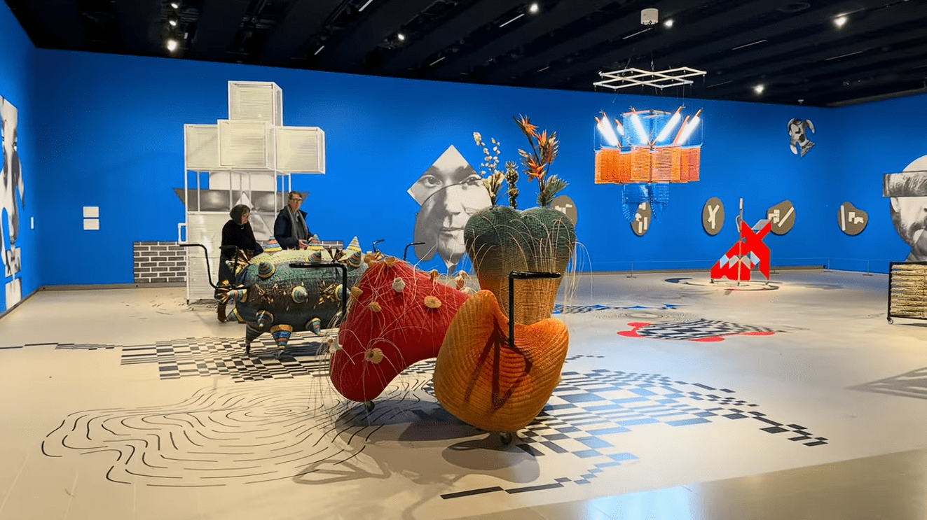 Visitors explore a vibrant contemporary art exhibition at Hayward Gallery in London, featuring large-scale colourful sculptures, immersive installations, graphic floor designs, and bold blue gallery walls.