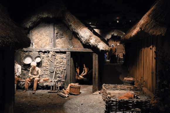 Authentic Viking village reconstruction at JORVIK Viking Centre in York featuring thatched timber houses, life-sized Norse residents, and everyday scenes from Viking-age England.