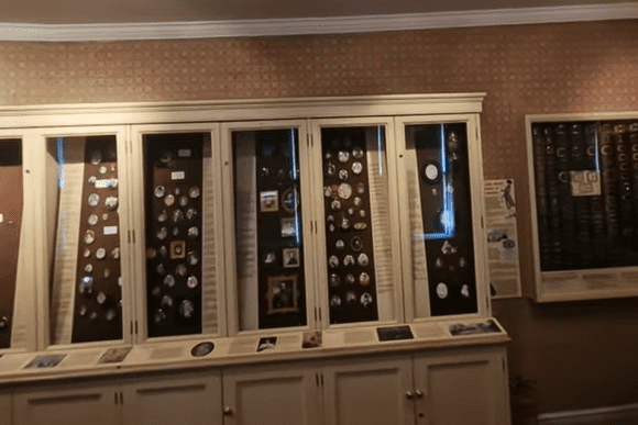Museum display cases at Kenwood House showing historical medals, coins, and small artefacts.