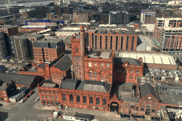 Aerial view of Liverpool’s Baltic Triangle showing historic red-brick industrial buildings, former warehouses and modern developments.