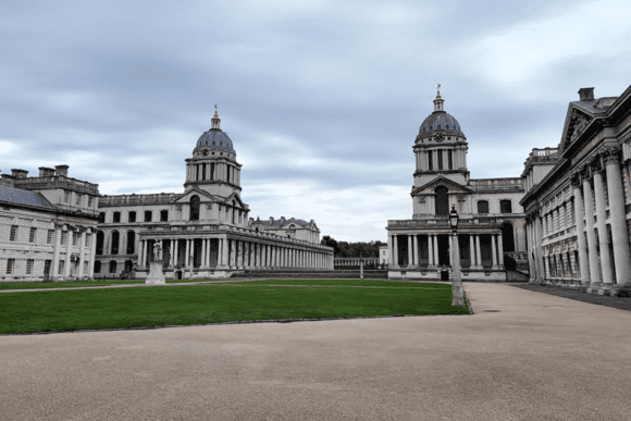 Wide view of the Old Royal Naval College at Greenwich with twin domed buildings and central lawn.