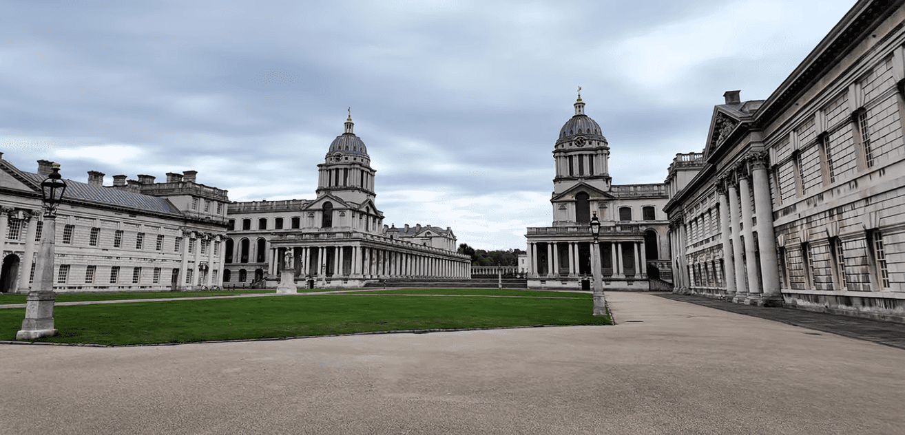 Wide view of the Old Royal Naval College at Greenwich with twin domed buildings and central lawn.