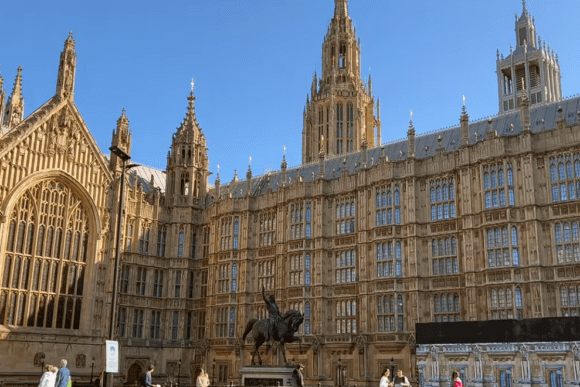 Palace of Westminster exterior courtyard with ornate Gothic architecture and statue, London.