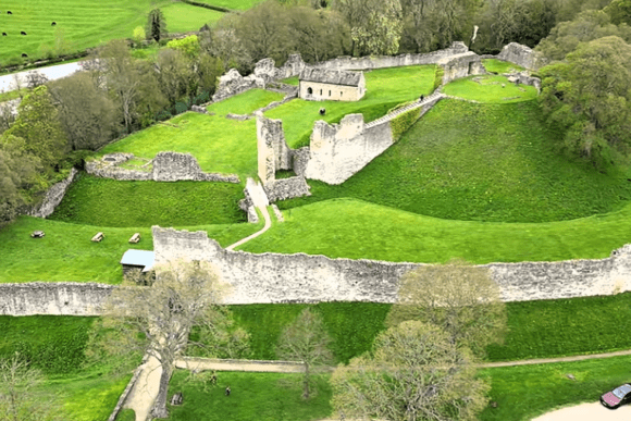 Aerial view of Pickering Castle showing medieval walls, towers, and green inner bailey.