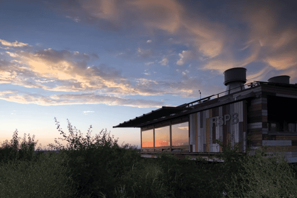 RSPB Rainham Marshes Visitor Centre at sunset, with dramatic clouds reflecting in the building’s glass façade, surrounded by wetlands and nature reserve vegetation in Essex.