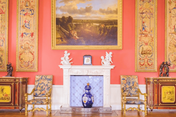 Interior of Ranger’s House in Greenwich, London, displaying ornate artwork, decorative panels, antique furniture, and a fireplace from the Wernher Collection.