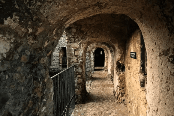 Interior passageway of Castle Rising Castle in Norfolk, England, showing stone arches, narrow corridors, and medieval architecture.