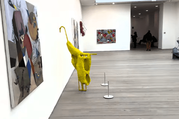 Contemporary artworks displayed inside Saatchi Gallery in London, featuring a bright yellow abstract sculpture, large-scale paintings, mixed-media installations, and visitors exploring the modern exhibition space.