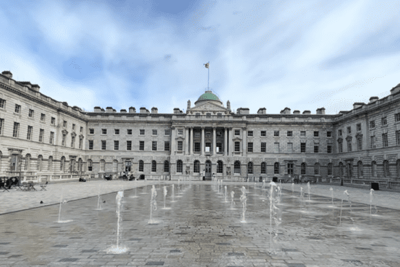 Somerset House courtyard in London with fountains, neoclassical architecture, and central building with a domed roof.