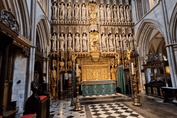 Ornate altar inside Southwark Cathedral London with golden reredos, carved statues, and Gothic arches.