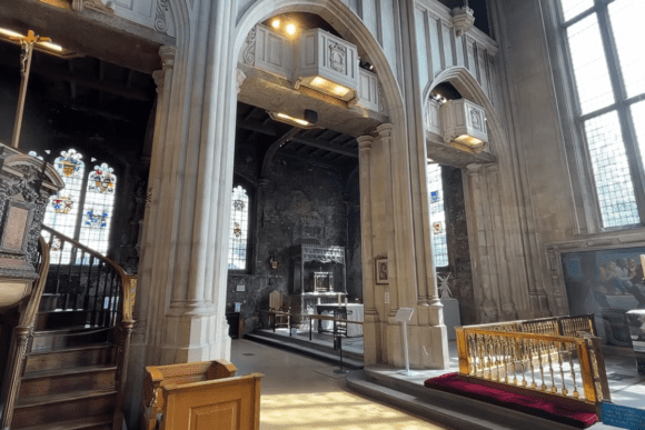 St Bartholomew-the-Great interior London with stone arches, ornate pulpit, stained glass windows, and side chapel.