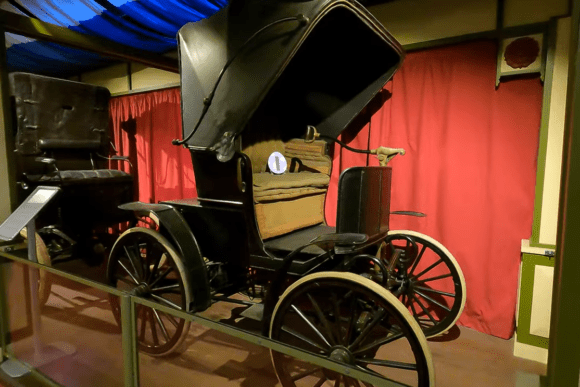 Historic horse-drawn carriage displayed at the Streetlife Museum of Transport in Hull, showcasing early road transport with wooden wheels, leather canopy, and authentic Victorian craftsmanship.