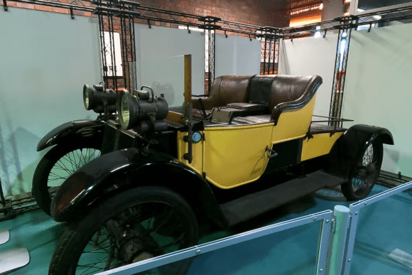 Vintage early twentieth-century motor car displayed at the Streetlife Museum of Transport in Hull, featuring brass headlamps, leather seating, and classic British automotive design.