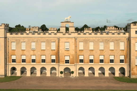 Front view of Syon House in London featuring grand Georgian architecture, crenellated towers, and arched colonnades.