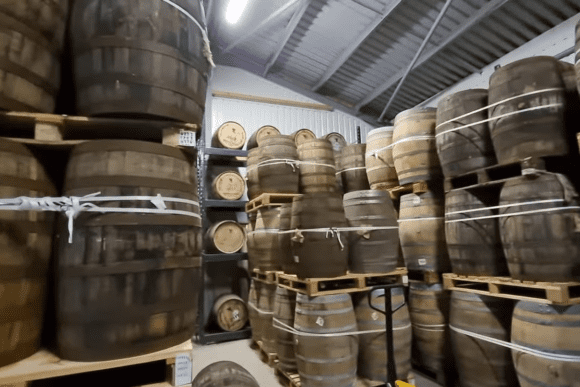 Rows of oak whisky casks maturing inside the Cotswolds Distillery barrel warehouse, where English single malt whisky is aged to develop its rich flavour and character.