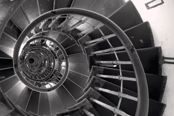Spiral staircase inside The Monument to the Great Fire of London showing the historic iron steps winding upward through the tower.